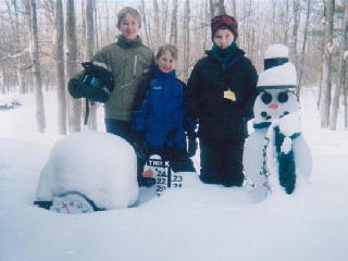 Matt and Jack Funk with Tyler Bettelon standing next to the snowman.