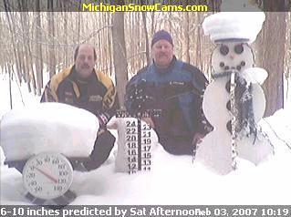 Chet Parisotto and Tom Wyatt kneeling next to the Snowman.